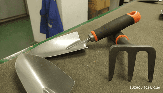 An assortment of professional-grade garden tools like trowels, pruning shears, and cultivators arranged neatly.
