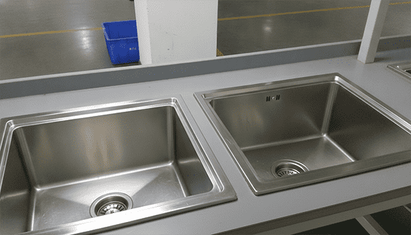 Comparison of 304 vs 201 Grade Stainless Steel Sinks A graphic comparing two sinks, one labeled '304 Grade / 16 Gauge' looking new, and another labeled '201 Grade / 22 Gauge' with simulated rust and a dent.