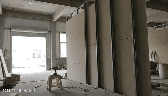 An installation photo showing MGO boards being fitted as wall partitions in a commercial bathroom, highlighting their use in a wet environment.