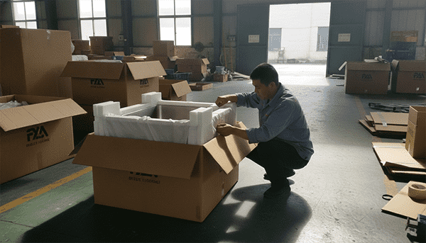 Proper export packaging for a stainless steel sink A photo showing a sink being packaged correctly: it is inside a soft fabric bag, has thick foam corner protectors, and is being placed in a strong cardboard box.
