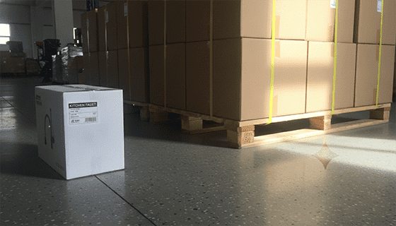 Image showing two types of packaging: a branded retail box for a faucet and bulk-packed hardware on a pallet.