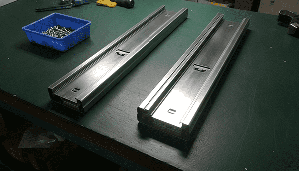 Close-up image showing a side-mounted ball-bearing slide and an undermount slide for a pull-out basket.