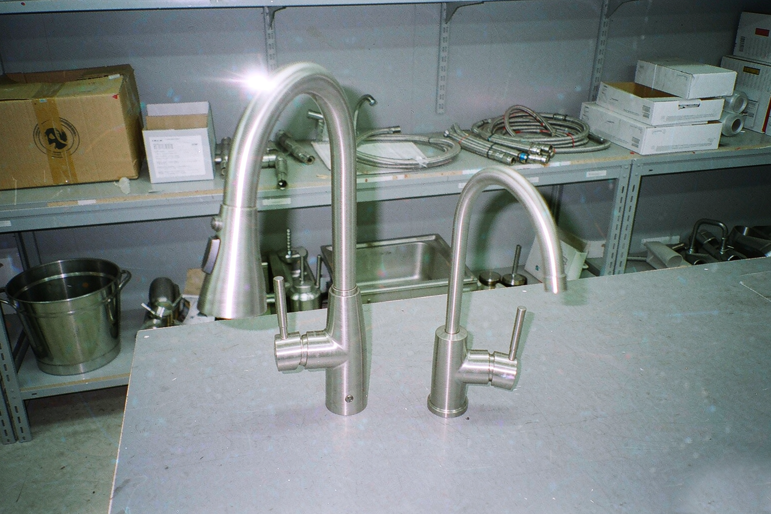A side-by-side comparison showing a high-arc pull-down faucet and a lower-profile pull-out faucet.